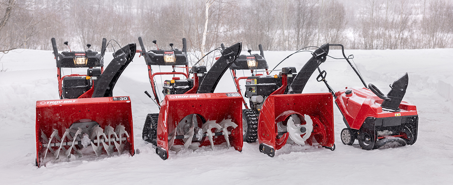 four troy bilt snow blower lined up in the snow